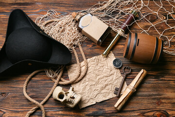 Pirate hat with rum, skull, map and net on wooden background © Pixel-Shot