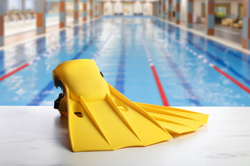 Swimming lesson. Yellow flippers by swimming pool © New Africa