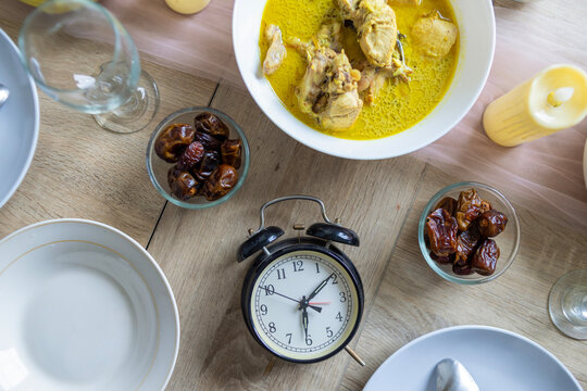 Top View Of Vintage Alarm Clock Surrounded By Dates And Opor Ayam For Iftar