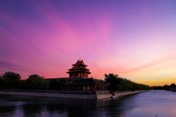 Obraz premium The corner towers of the Forbidden City in China and the beautiful sunset glow at dusk.
