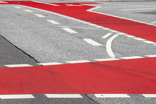 Abstract traffic crosswalk detail with red white lines and worn asphalt road marking at intersection for urban infrastructure texture
