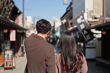 Fototapeta premium 柴又の観光地を歩くカップルの後ろ姿