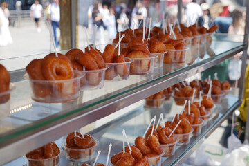 turkish donuts in small cups at a busy market stand