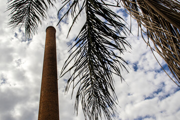 Chimney built with bricks, dry palm leaves and the sky with many clouds in the background, in Brazil