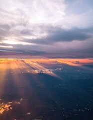 Aerial view of a radiant sunset, piercing clouds with golden beams