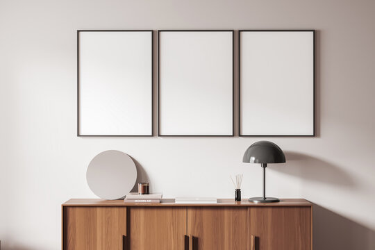Blank framed posters in modern interior setting on light wall background showing clean layout concept for creative display and template use, 3D Rendering