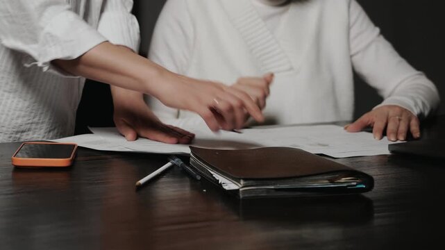 Close up of business colleagues exchanging documents during office work. Paperwork process, document flow and professional collaboration at modern workplace indoors.
