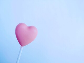 Pink heart-shaped candies are placed on a white background.