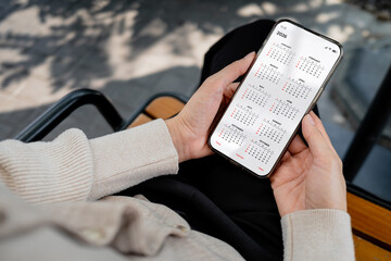 Woman checking calendar on smartphone outdoors. Digital planning, schedule management, time organization and productivity lifestyle concept