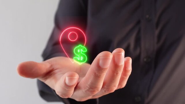 Property costs by location. Close-up of a businesswoman's hand holding a virtual location pin icon with a dollar sign.