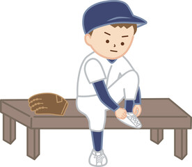 野球のユニフォーム姿で靴紐を結ぶ男の子