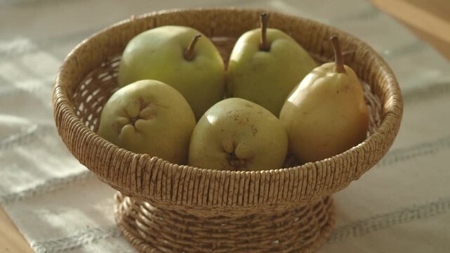 Fresh pears in a woven basket on a table