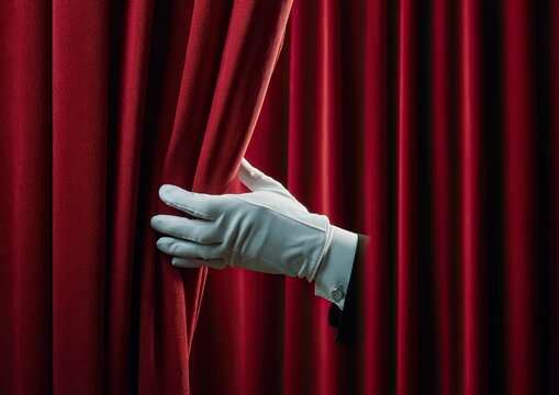 White-gloved hand pulling back a rich, red velvet curtain