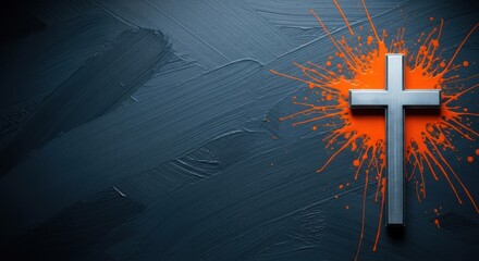 A silver cross with vibrant orange splatter on a dark background