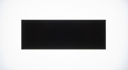 Obraz premium Black rectangular magnet sheet isolated against a white background, showcasing minimalist design and stark contrast