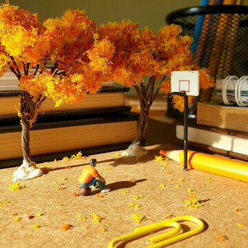 Miniature scene on the office desk with unfocus book and blurred stationery stuff.