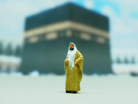 Mini toy of action figure at outdoor with blurred background. Miniature photography concept design. Minifigure of muslim character pray at Masjid. Ramadan ied al fitr and al adha at mataf