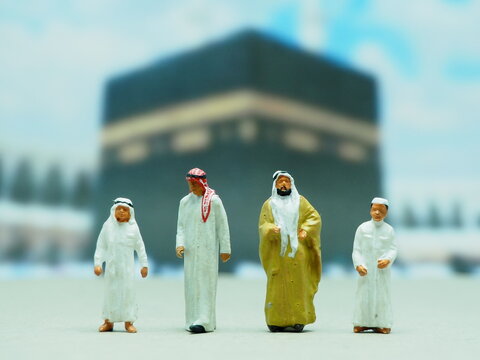 Mini toy of action figure at outdoor with blurred background. Miniature photography concept design. Minifigure of muslim character pray at Masjid. Ramadan ied al fitr and al adha at mataf
