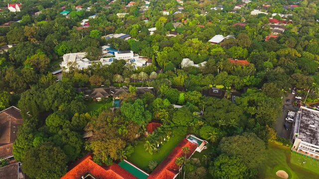 Early morning glow reveals prestigious BGC villas amid dense trees, Manila