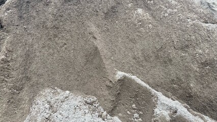 A pile of fine sand as a building construction material with a clearly visible natural texture, suitable to describe the basic material for concrete and plastering work. © RiyanBudi