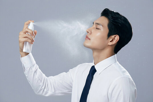 Man applies skin spray in a studio setting during daytime for skincare routine