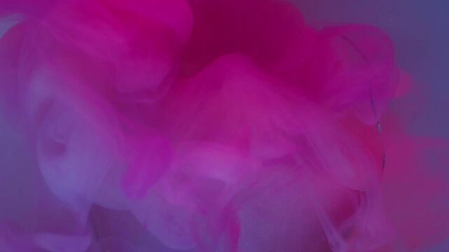Fluorescent ink. Swirling mist. Defocused pink blue purple color filling broken light bulb spreading on abstract acrylic art neon background.