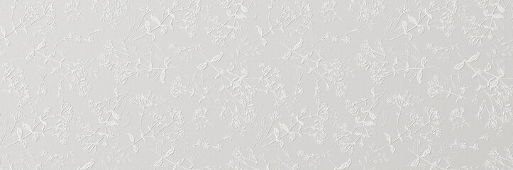 A subtle white embossed floral pattern with delicate leaves and blossoms creating an elegant textured wallpaper background.