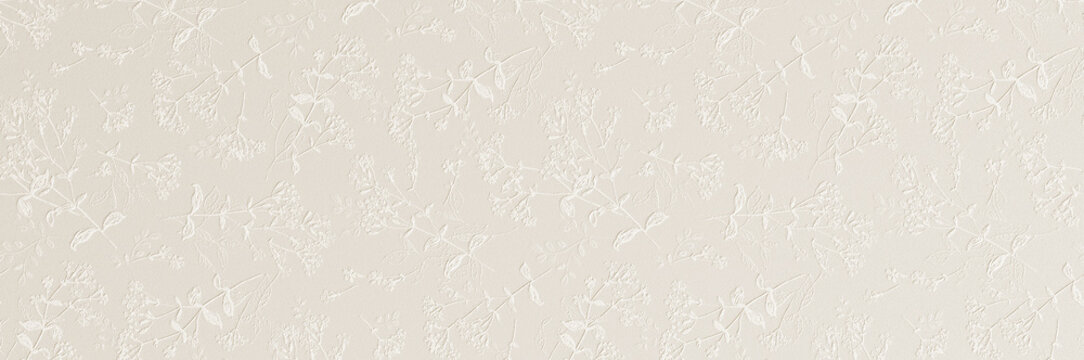 A subtle white embossed floral pattern with delicate leaves and blossoms creating an elegant textured wallpaper background.