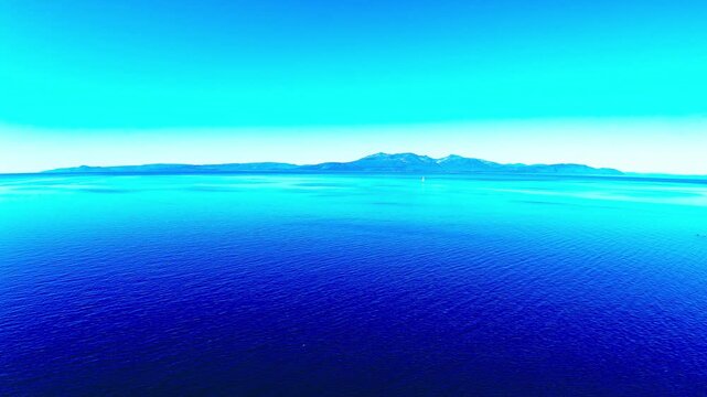 Aerial view from Ayrshire across the Firth of Clyde to the Isle of Arran, Scotland, UK, showing calm blue water, haze and distant peaks on the horizon