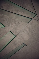 A background consists of grey concrete pieces overlapping in a geometric design. There are spaces between the concrete that are green. Provides a unique abstract concept.
