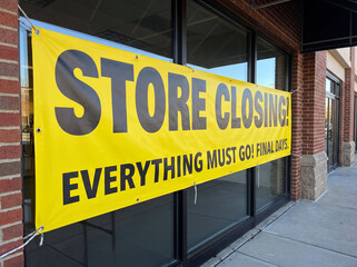 Obraz premium Yellow store closing banner hanging on a retail storefront window