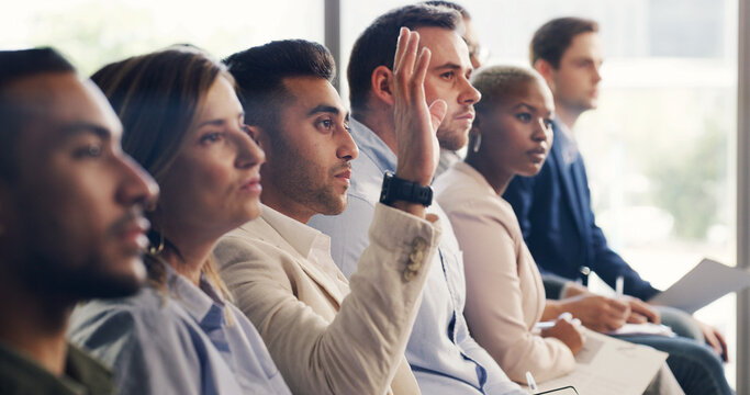 Man, raised hand and audience at conference for business people for questions, insight or feedback. Person, crowd and gesture for review, workshop or group with notes at corporate training convention