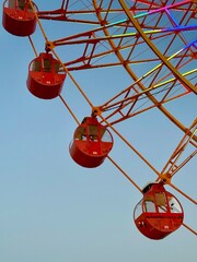 Fototapeta premium The luminated big red ferris wheel ride during the sunset.