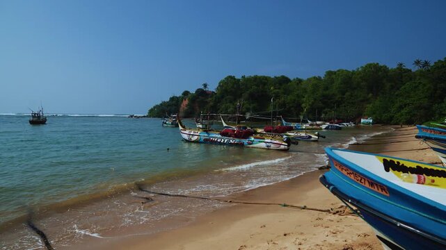 Traditional colorful fishing boats with outriggers lined up on beach, Weligama coast, Sri Lanka