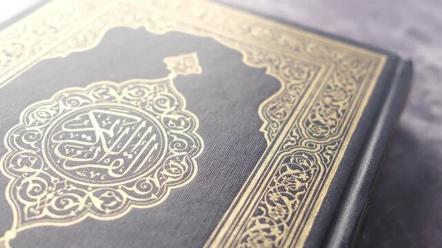 Close up on ancient Quran book cover with gold arabic calligraphy and ornaments