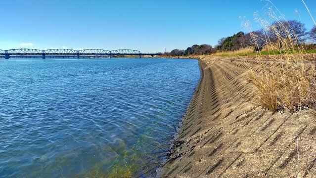 冬の青空と広大な河川敷の堤防背景
