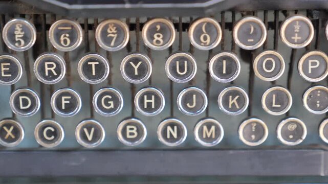 Close up camera movement on vintage qwerty typewriter keyboard showcasing antique technology and historical writing tools