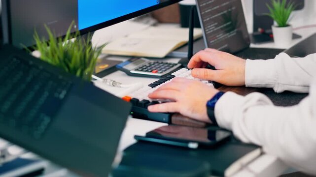 Software development workspace computer coding office desk. Programmer hands typing keyboard, multiple screens display source code, modern technology environment, remote work concept