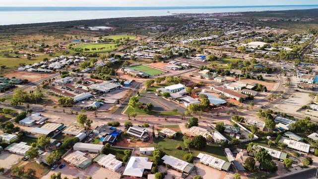 Birds eye perspective showcasing Exmouth neighborhood houses coastal township harbor turquoise ocean backdrop Australia