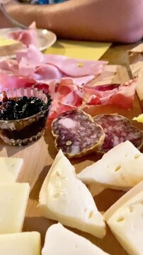  Close-up of a traditional Italian antipasto platter with cheese, salami, and jam.