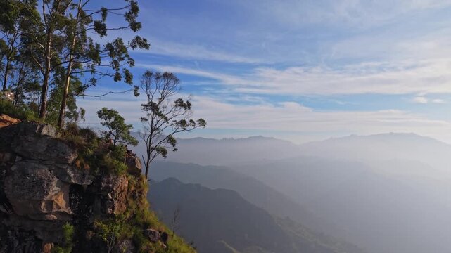 Cinematic drone shot of hikers sitting on cliff edge of Ella rock in Sri Lanka