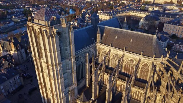 Aerial drone view of the bell tower, clock,and roof of the historic Saint Julien Cathedral, Le Mans in France during a beautiful sunset