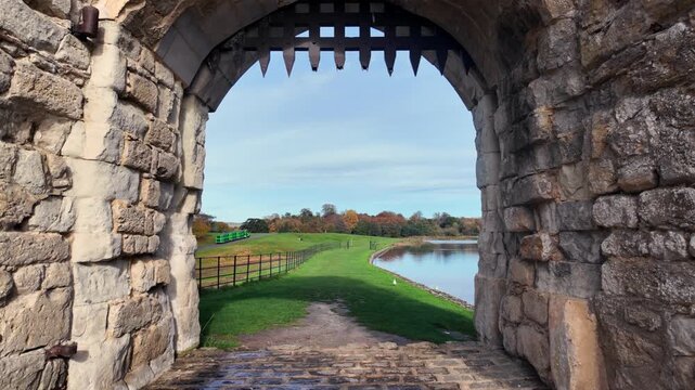 Forward POV through medieval gate revealing moat at Leeds Castle UK