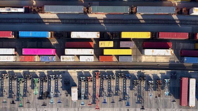 Aerial view of a container terminal with freight trains carrying colorful containers.