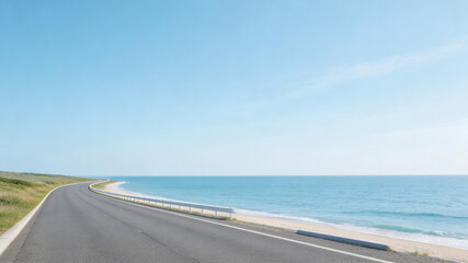 Fototapeta premium A long, smooth coastal highway curves along a sandy beach with clear blue ocean waters under a bright, cloudless sky, offering a serene and picturesque drive.