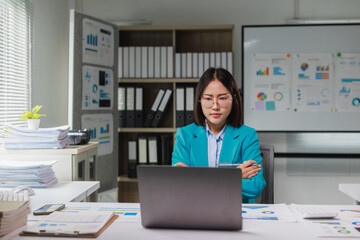 Asian businesswoman analyzing data and planning strategy in office