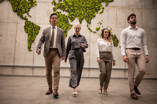 Business team walking in modern office with world map