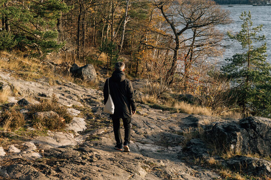 Man Walking on Rugged Rocky Path by the Water