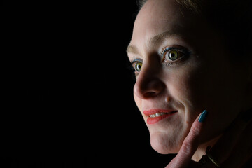 Naklejka premium Low-Key-Portrait eines Models im Mantel vor dunklem Hintergrund. Dramatisches Licht, starke Schatten und roter Lippenstift setzen elegante, ausdrucksstarke Akzente.