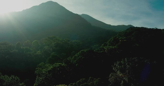 Cinematic Drone View of Sunlight Rays Over Tropical Mountain Forest
